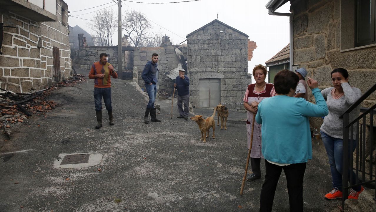 Vecinos de As Fermosas, concello de Carballeda de Avia, ante las viviendas afectadas por las llamas