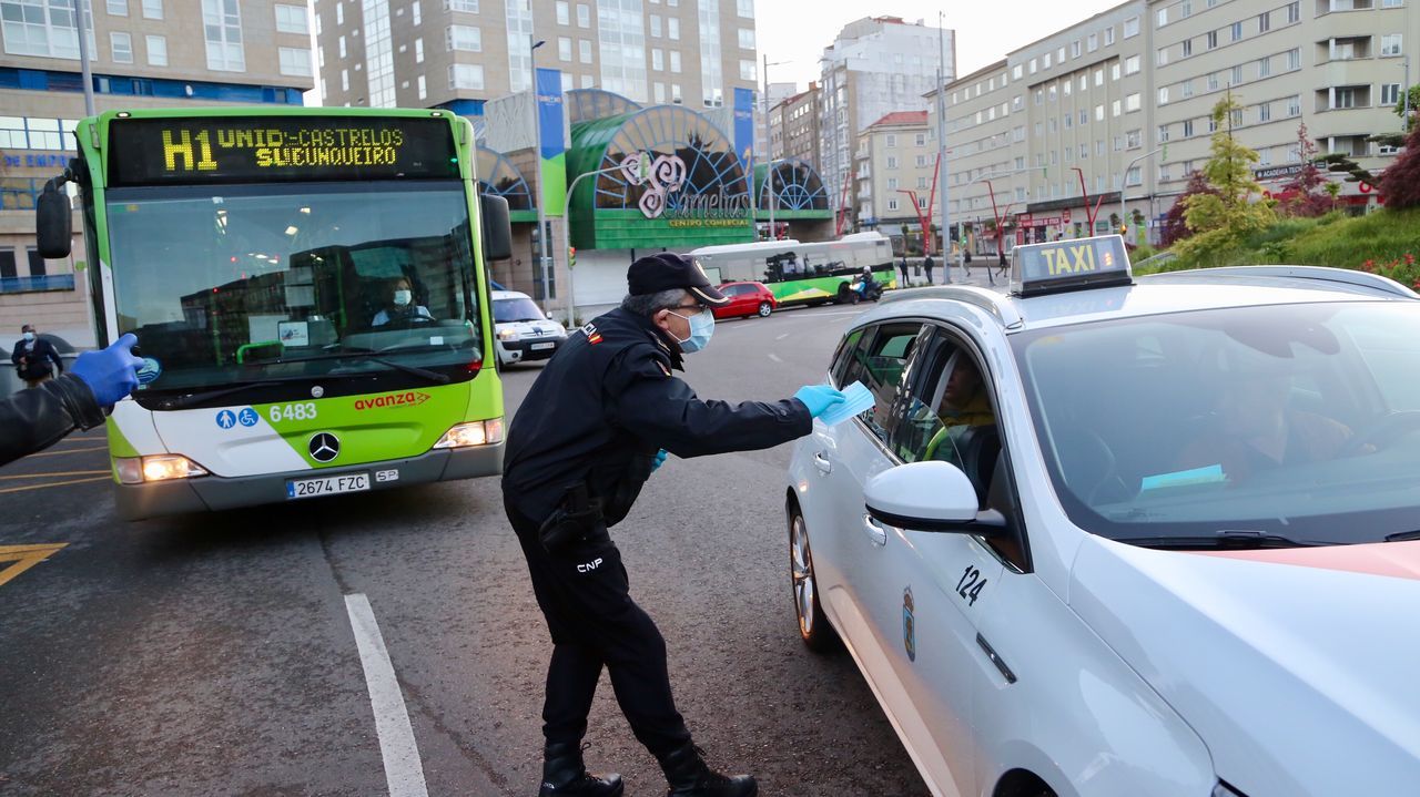 Policía Nacional, Local y Autonómica reparten mascarillas a transeúntes y conductores en la plaza de América de Vigo
