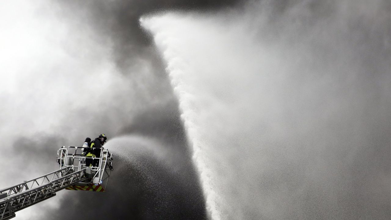 Los bomberos trabajando afanosamente en el incendio industrial que sufrió Impex Europa en el polígono de Trabanca