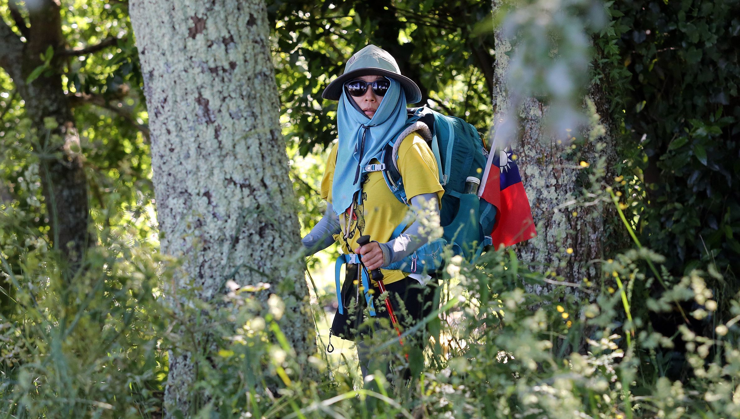 Unha peregrina taiwanesa cbrese do vento e o sol ao seu paso por Pontearnelas (Vilanova de Arousa). 03/06/2024