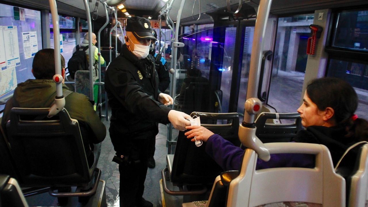 Policia local de Narón y Policía Nacional reparten mascarillas a usuarios del transporte público urbano en la carretera de Castilla en O Alto