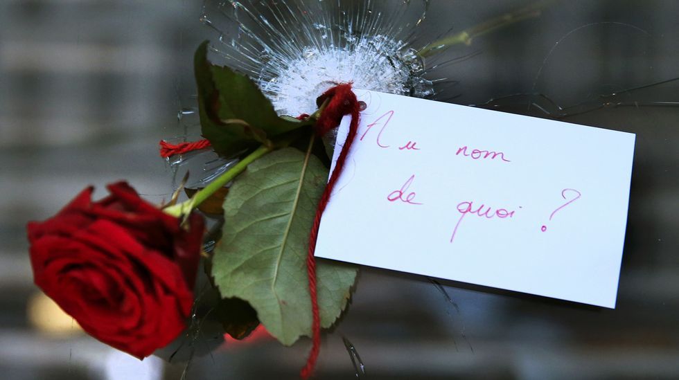Una rosa colgada a través del agujero de la cristalera de uno de los establecimientos tiroteados en París.