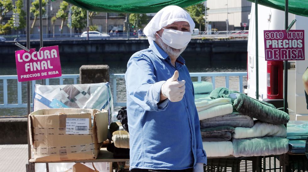 Regresa la feria de los sabados a Pontevedra con nuevas medidas anticontagio. Un vendedor se protege del coronavirus con una mascarilla y unas bragas de algodón en la cabeza
