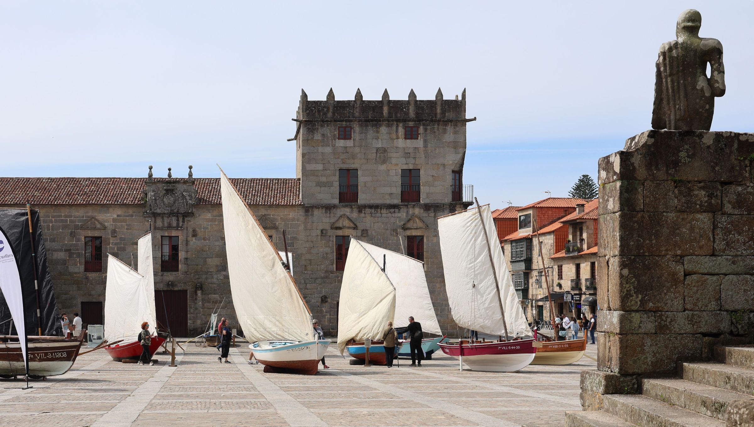Dornas varadas na praza de Fefins coas velas en alto no Da das Letras Galegas. 17/05/2025