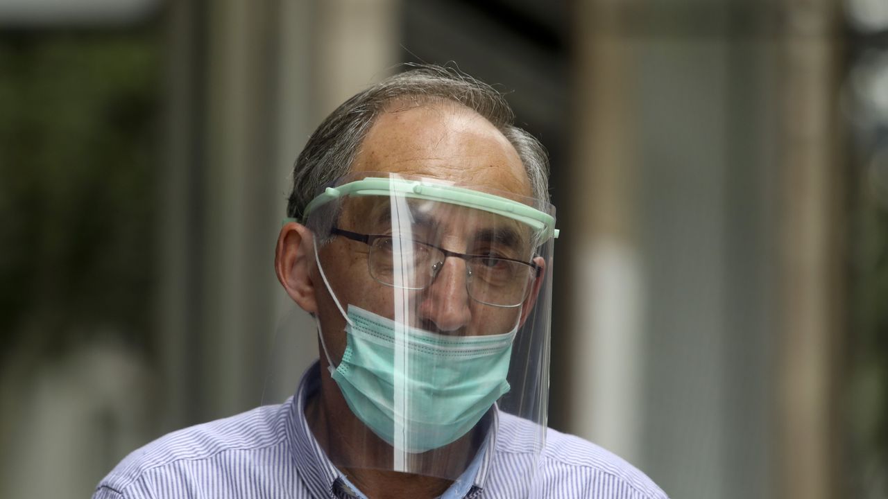 Con mascarilla y prrotector de plástico por las calles de Santiago
