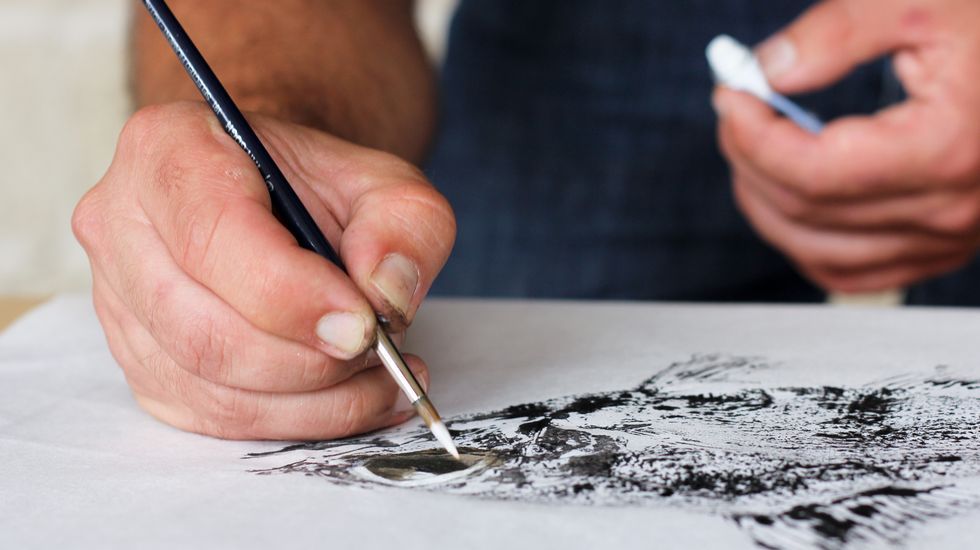 peixes de tinta.Esteban Bernárdez aplica pintura acrílica blanca para dar brillo a la obra