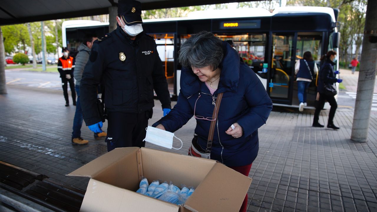 Policía Local y Nacional reparten mascarillas a los usuarios de los autobuses en Pontevedra