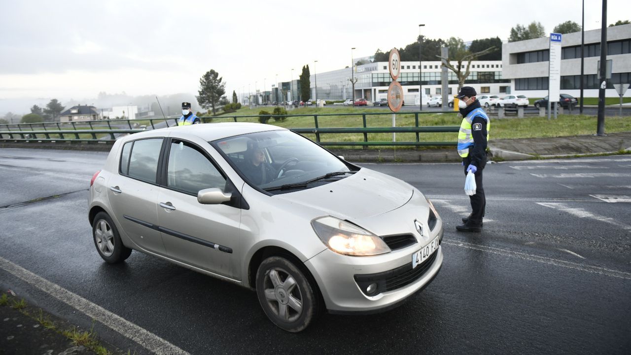 Reparto entrega de mascarillas por la Guardia Civil y Policía OLocal a trabajadores en la entrada del polígono industrial Lalin 2000