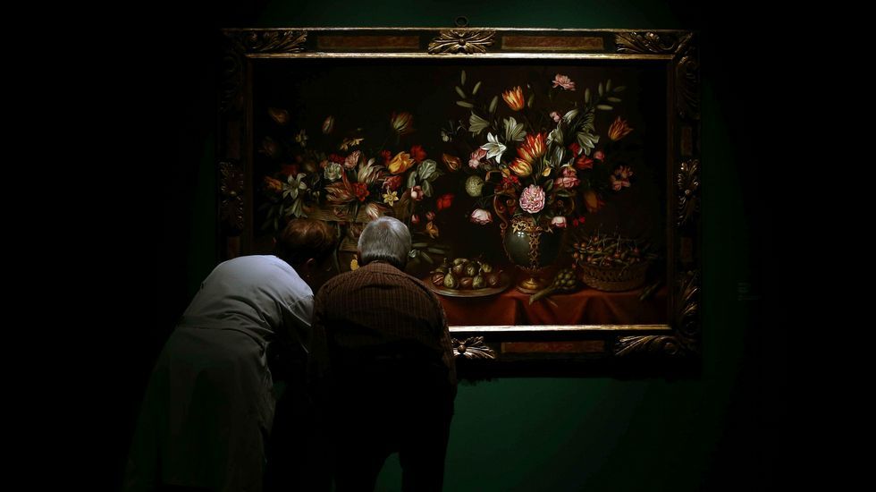 Restauradores repasan el marco de «El mes de mayo» de Antonio Ponce, una de las obras de artistas españoles exhibidas en el Museo Nacional de Arte de Cataluña