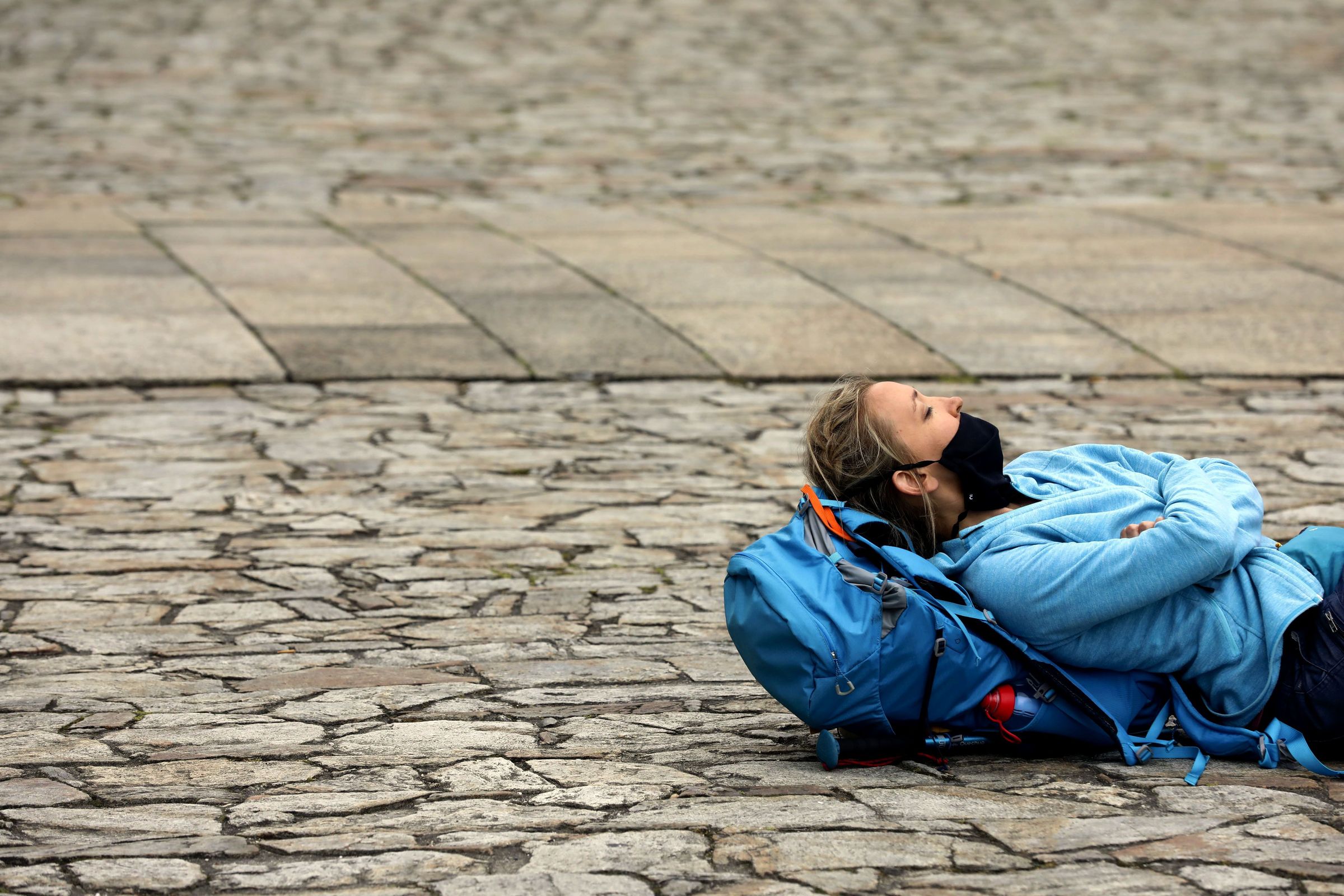 Peregrina descansa no chan da Praza do Obradoiro tras a s�a chegada a Santiago. 21/06/2021