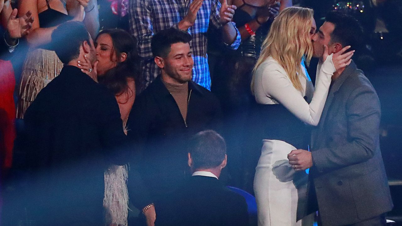 Jonas Brothers celebrando junto a sus parejas su premio