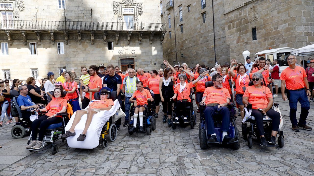 Llegada de seis afectados de ELA a la plaza del Obradoiro.Un peregrino de Corea del Sur pasa por delante de la Catedral con una bandera de su pa�s
