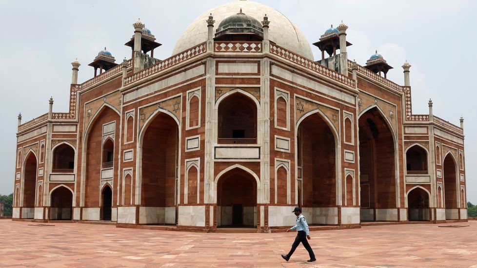Un guardia camina delante de la tumba de Humayun en la India, que hoy reabre sus puertas tras tres meses de confinamiento