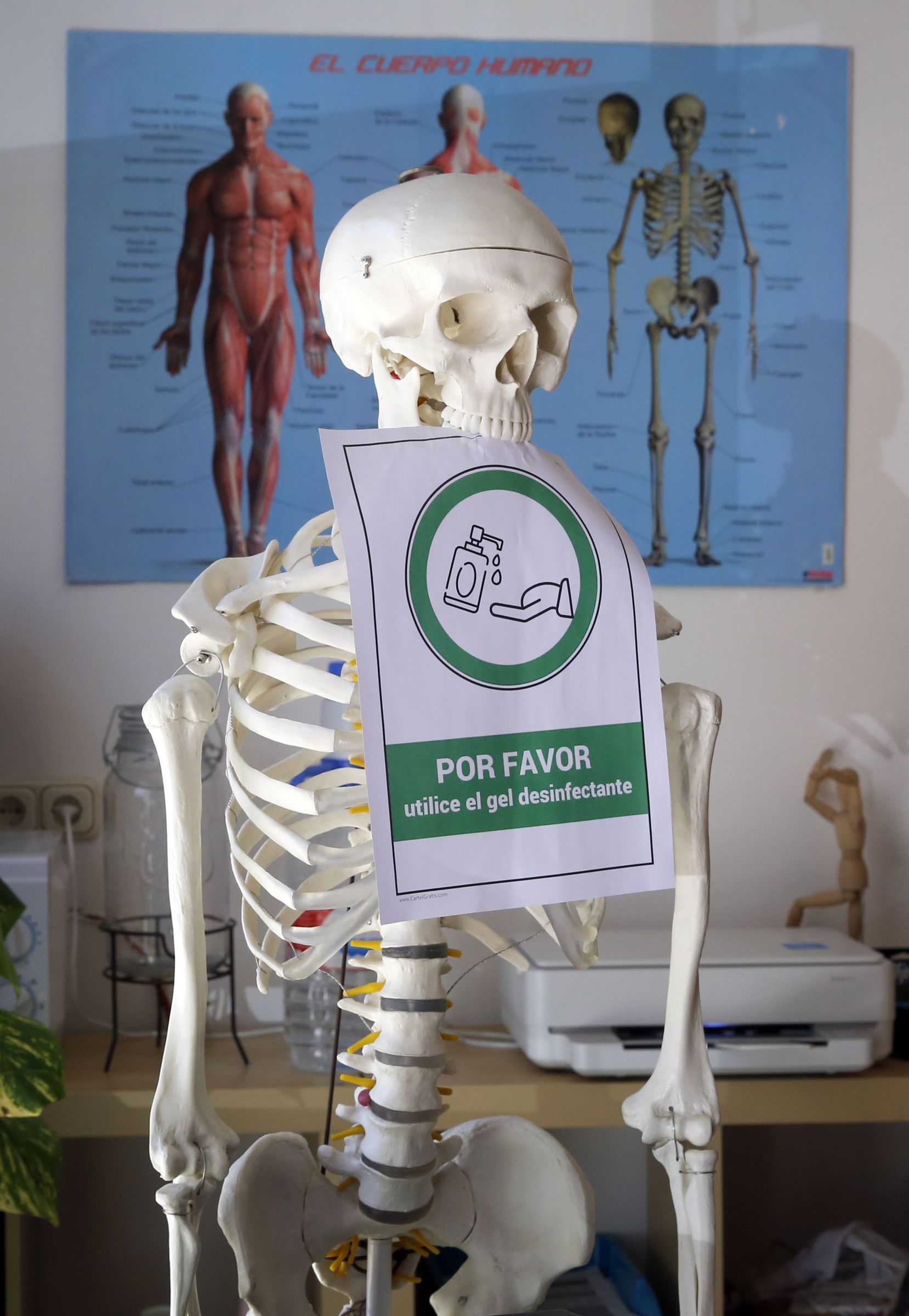 Un esqueleto suxeita un cartel de aviso de xel desinfectante nunha cl�nica de Vilagarc�a. 11/06/2021