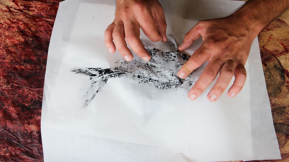 peixes de tinta.Cada esquina es importante, Bernárdez presiona el papel sobre el pez hasta que queda totalmente estampado
