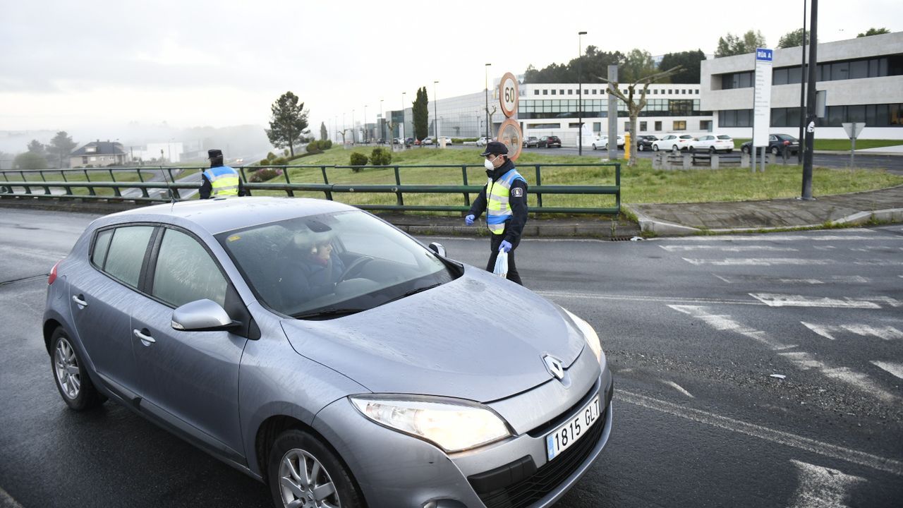 Reparto entrega de mascarillas por la Guardia Civil y Policía Local a trabajadores en la entrada del polígono industrial Lalin 2000