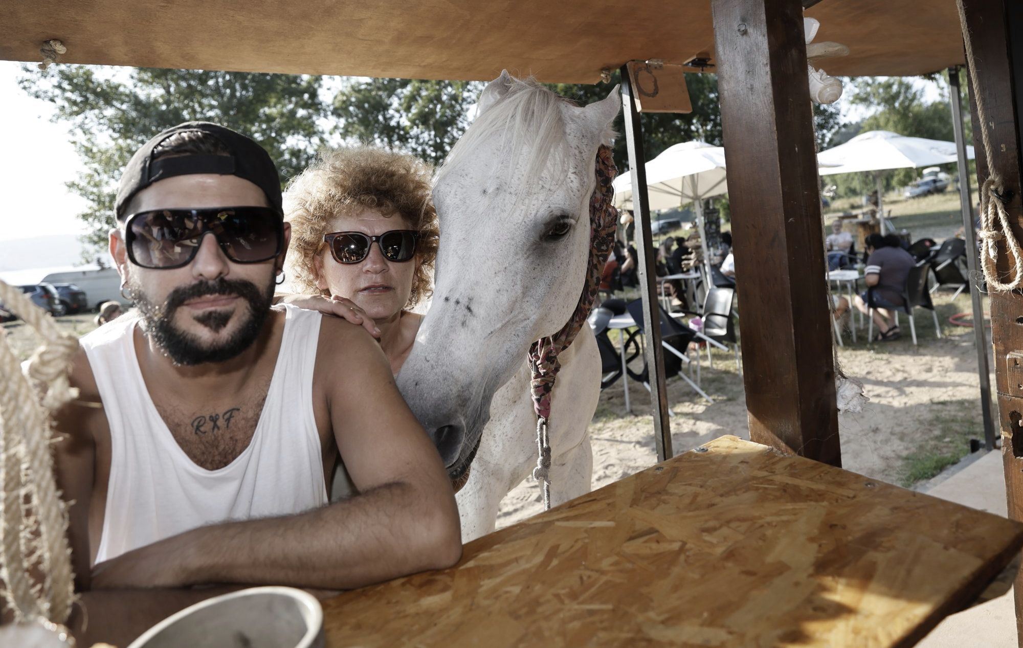 Chiringuito Kenia. O perruqueiro Richard Por Favor coa dona do chiringuito Kenia e o cabalo desta, na praia de Area onde corta o pelo unha vez  semana. 10/07/2025