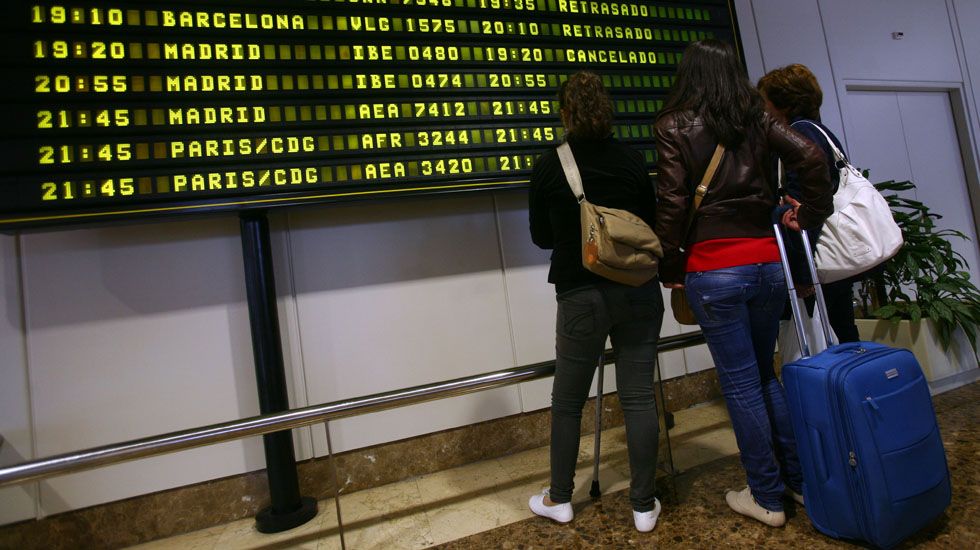 Un grupo de pasajeros consulta los vuelos en el Aeropuerto de Asturias.Un grupo de pasajeros consulta los vuelos en el Aeropuerto de Asturias