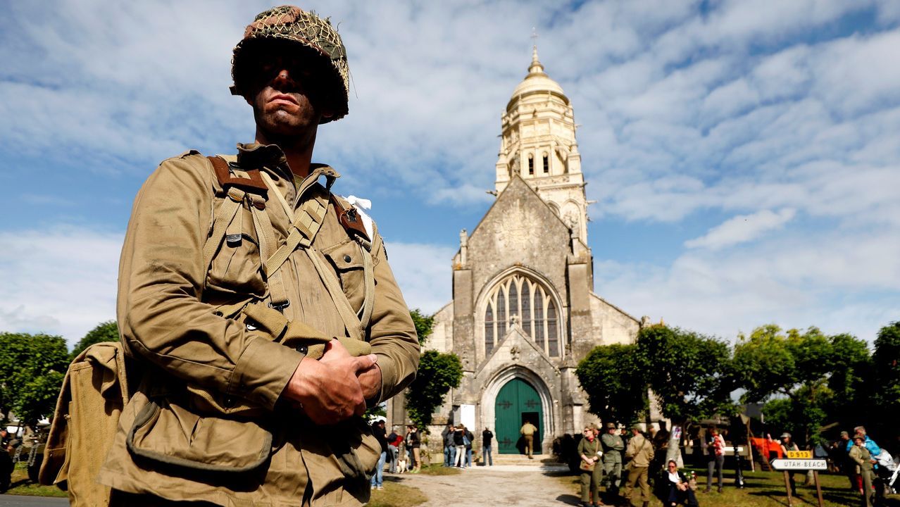 hombre caracterizado de soldado participa en la dramatización histórica del Día D este lunes en la iglesia Sainte Marie Du mont en la costa de Normandía