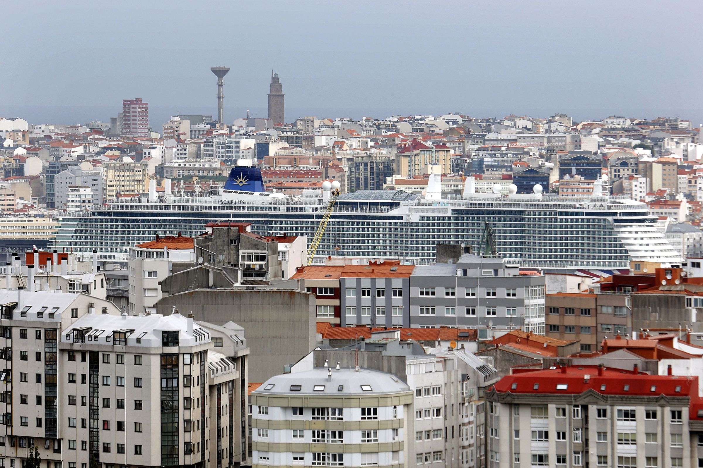 Un cruceiro atracado no porto de A Corua visto entre edificios. 03/09/2024