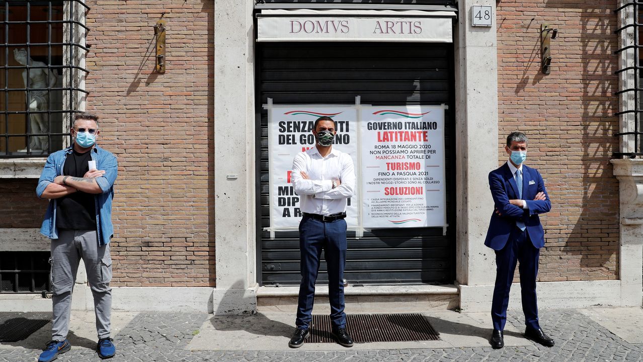 Un camarero, con guantes y mascarilla, sirve un café a un cliente, esta mañana en una plaza de Roma