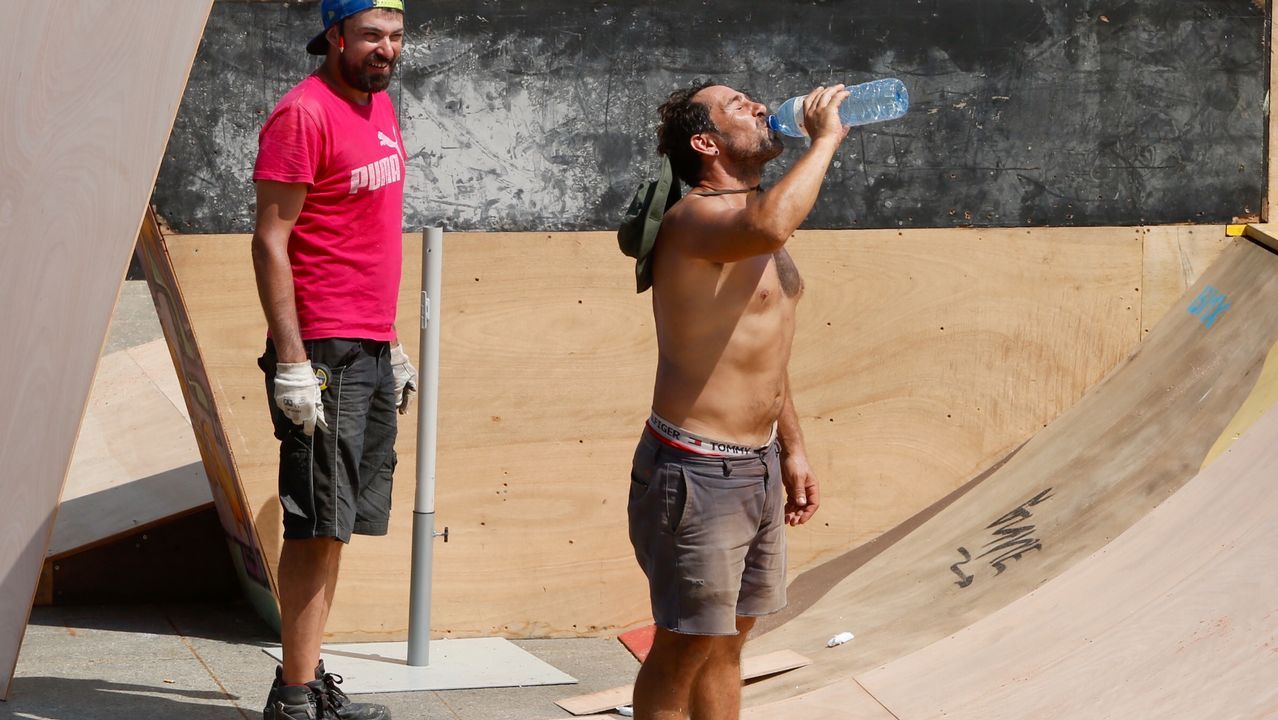 Un trabajador se refresca mientras trabaja a pleno sol