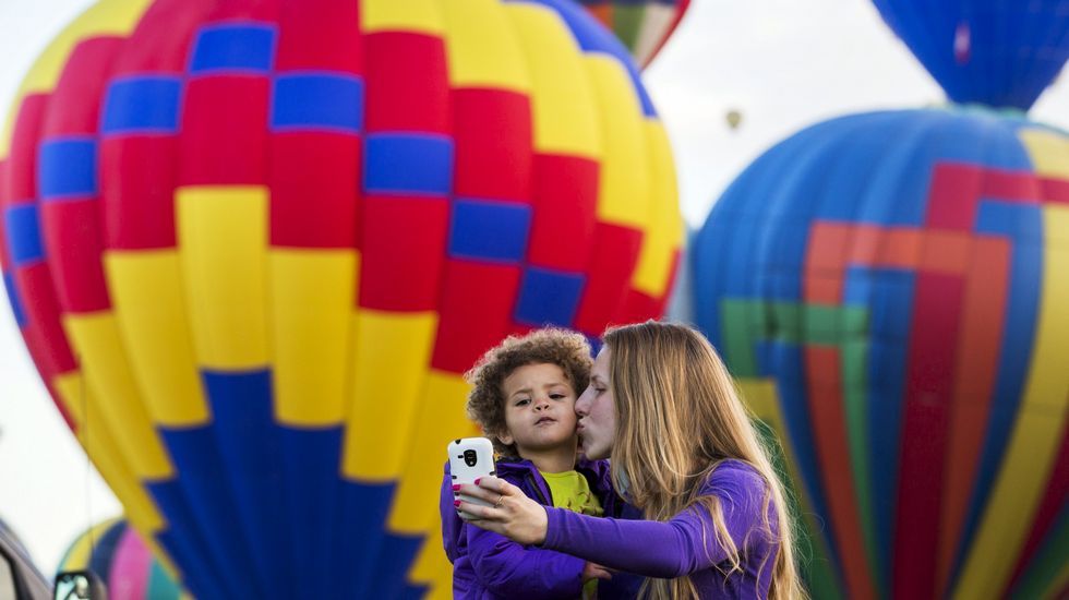 Una mujer y un niño toman una fotografía durante la Fiesta Internacional del Globo en Albuquerque.