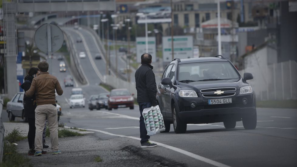 GENTE CRUZANDO LA MEDIANA DE LA CARRETERA BAÑOS DE ARTEIXO. ZONA DE MARINEDA CITY