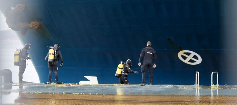 Los buzos inspeccionan el casco del buque que chocó con el pesquero