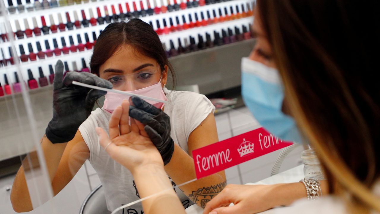 Un camarero, con guantes y mascarilla, sirve un café a un cliente, esta mañana en una plaza de Roma