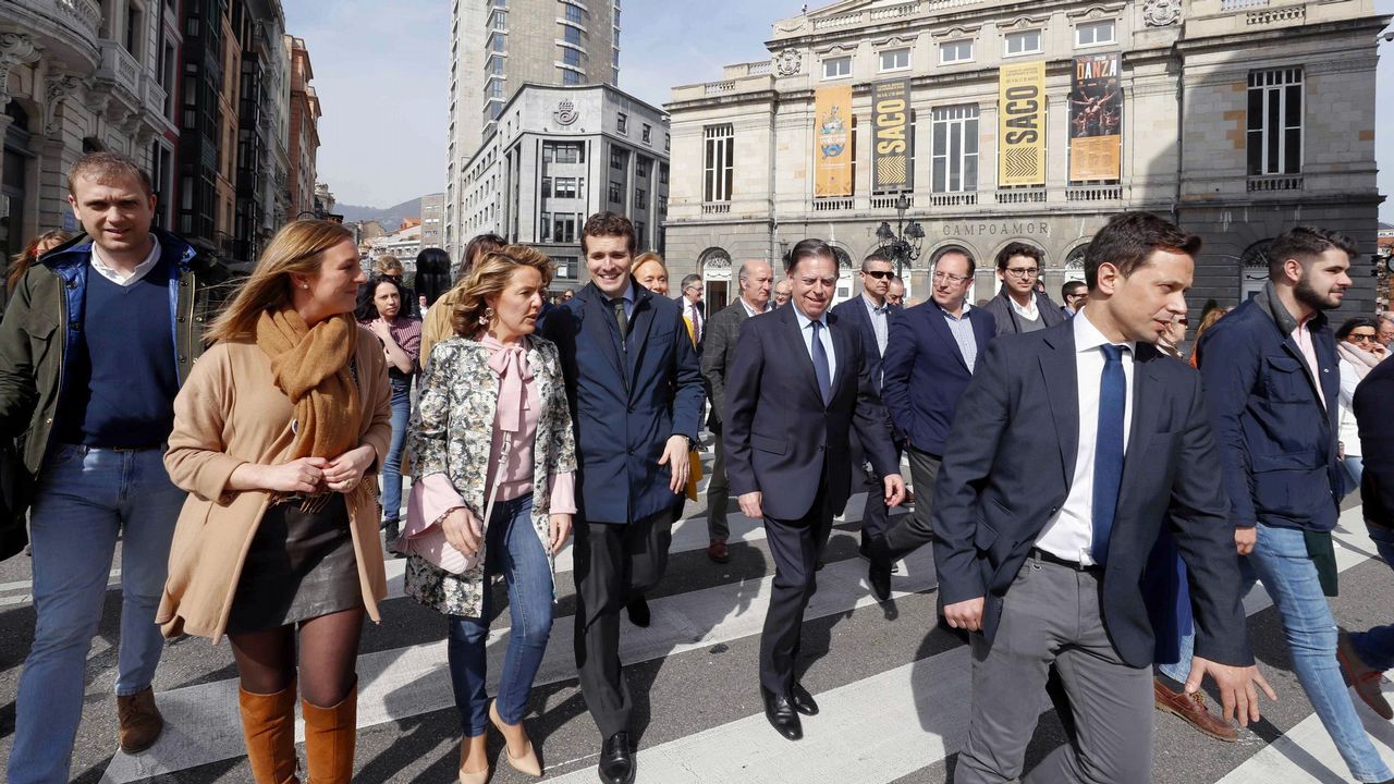 El presidente del PP, Pablo Casado (4i), y la candidata del PP a la Presidencia del Principado, Teresa Mallada (3i), pasan frente al teatro Campoamor de Oviedo tras la firma del acuerdo por el que PP y Foro Asturias concurrirán en coalición a las elecciones generales del 28 de abril.