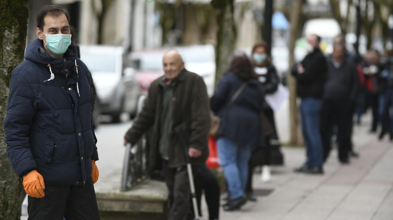 Vecinos de Lalín con mascarillas esperando para entrar en un banco
