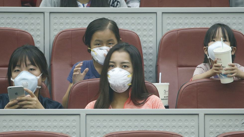 Espectadores con mascarillas durante un partido de tenis femenino individual en Pekín.