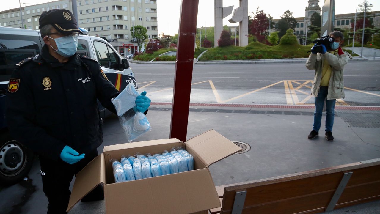 Policía Nacional, Local y Autonómica reparten mascarillas a transeúntes y conductores en la plaza de América de Vigo