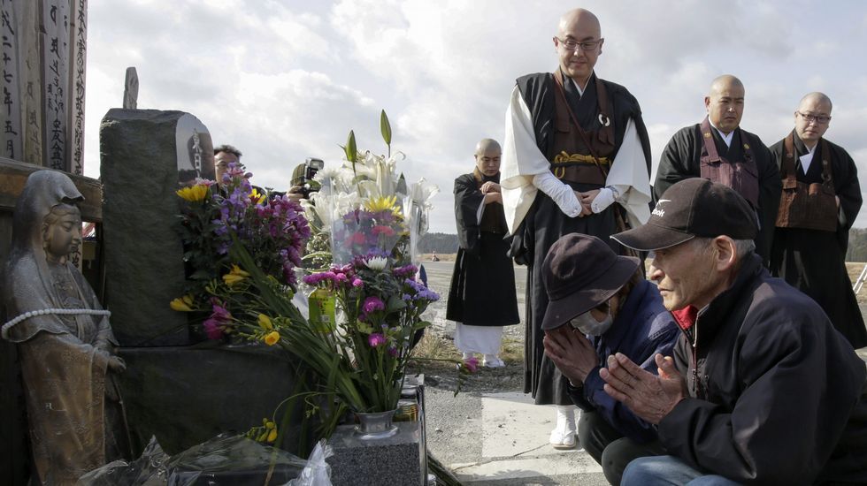 Karyo Okanuma y Yoshiko rezan junto a un grupo de monjes budistas en memoria de las víctimas.
