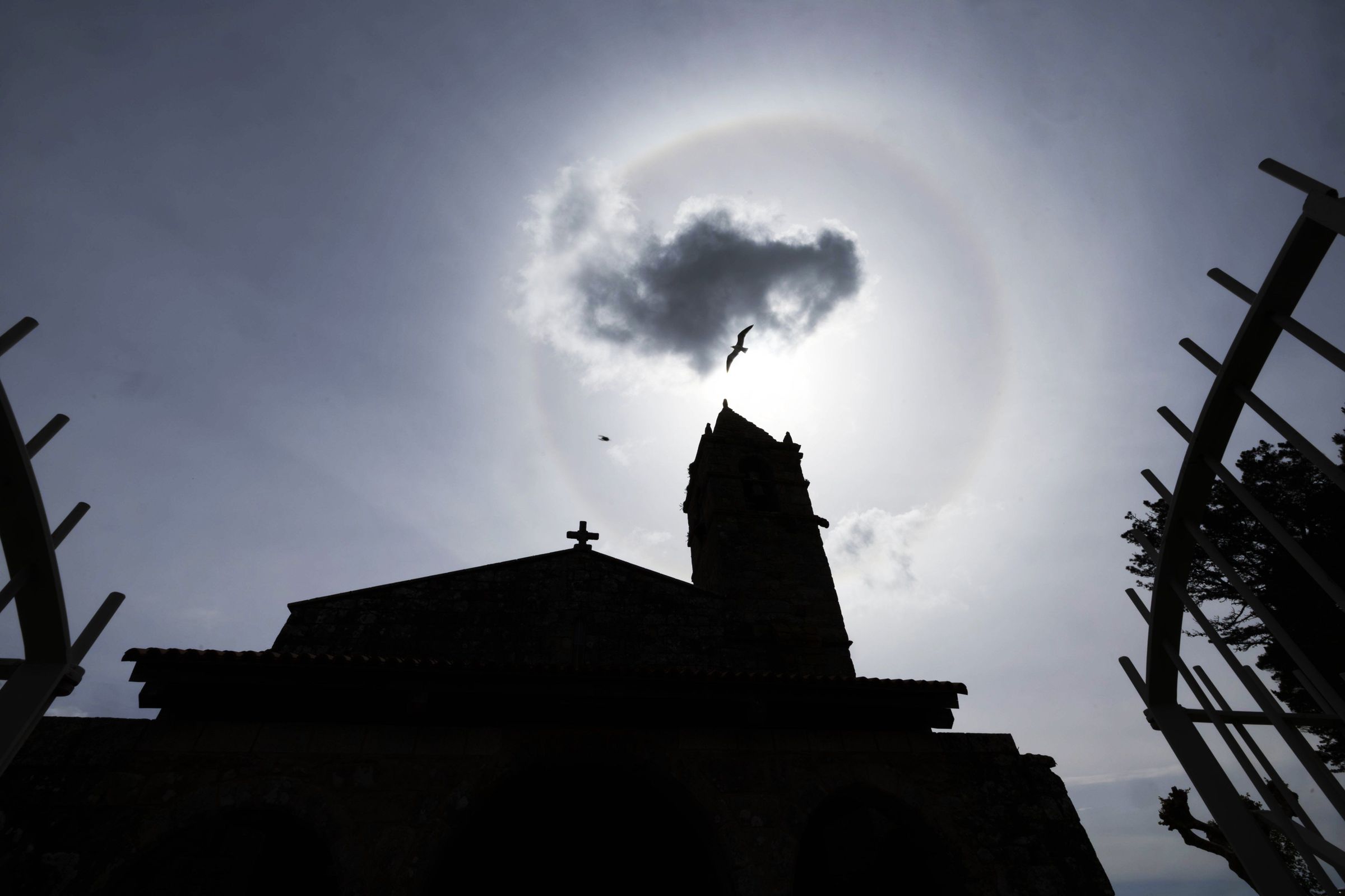 Un halo solar no ceo sobre a igrexa de Santa Mar�a de Ares vaticina o cambio de tempo. Este fen�meno astron�mico � causado pola refracci�n de luz solar a trav�s de cristais de xeo nas nubes. 29/04/2024