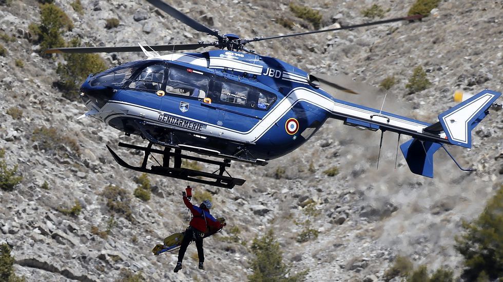 Un helicóptero transporta a un miembro del operativo a la zona del impacto.
