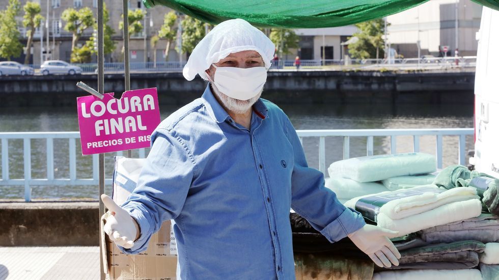 Reapertura de la feria de los sabados con nuevas medidas de seguridad. Un vendedor se protege del coronavirus con una mascarilla y una braga de algodón en la cabeza