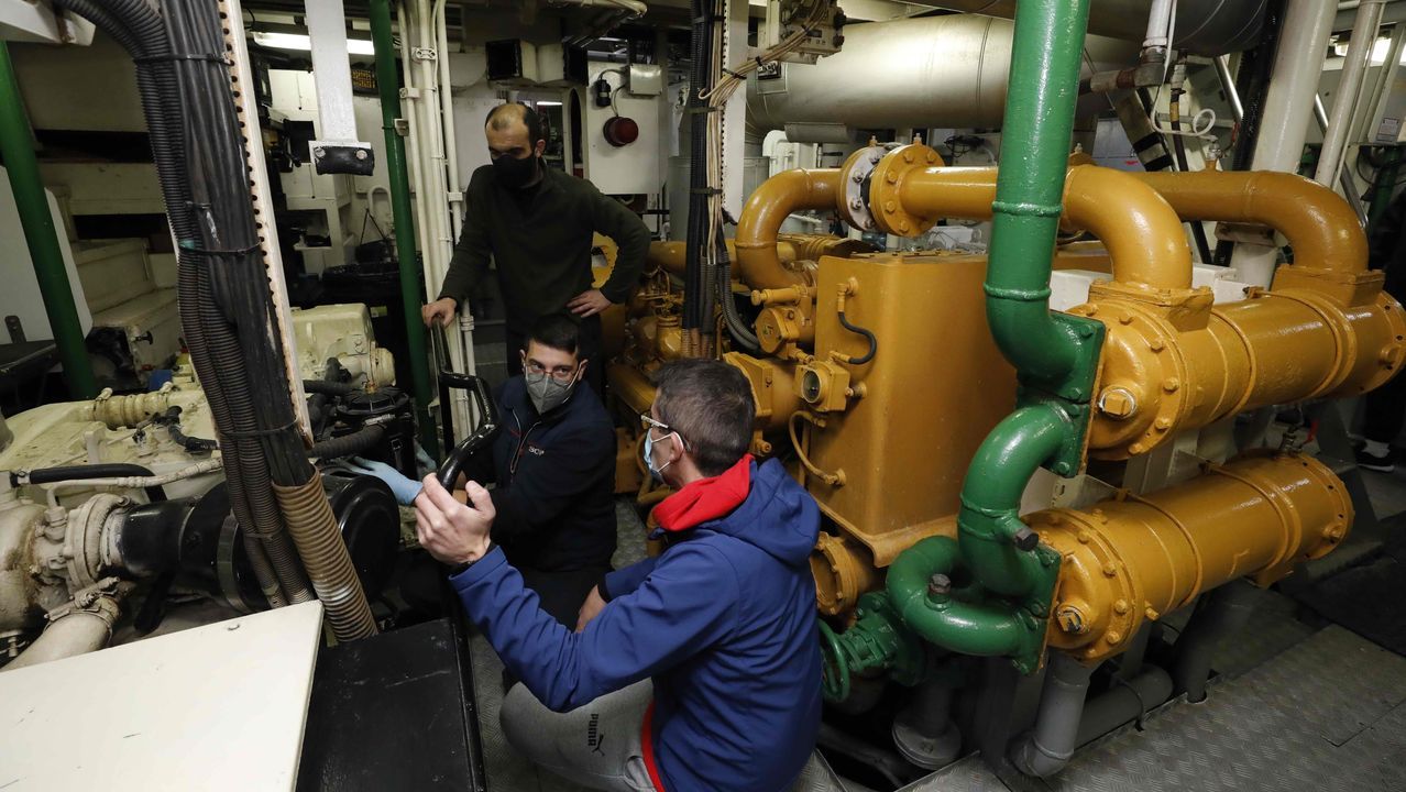 Técnicos de una empresa externa revisando una parte del motor principal, trabajo clave para zarpar que coincidió durante la visita al palangrero de fondo