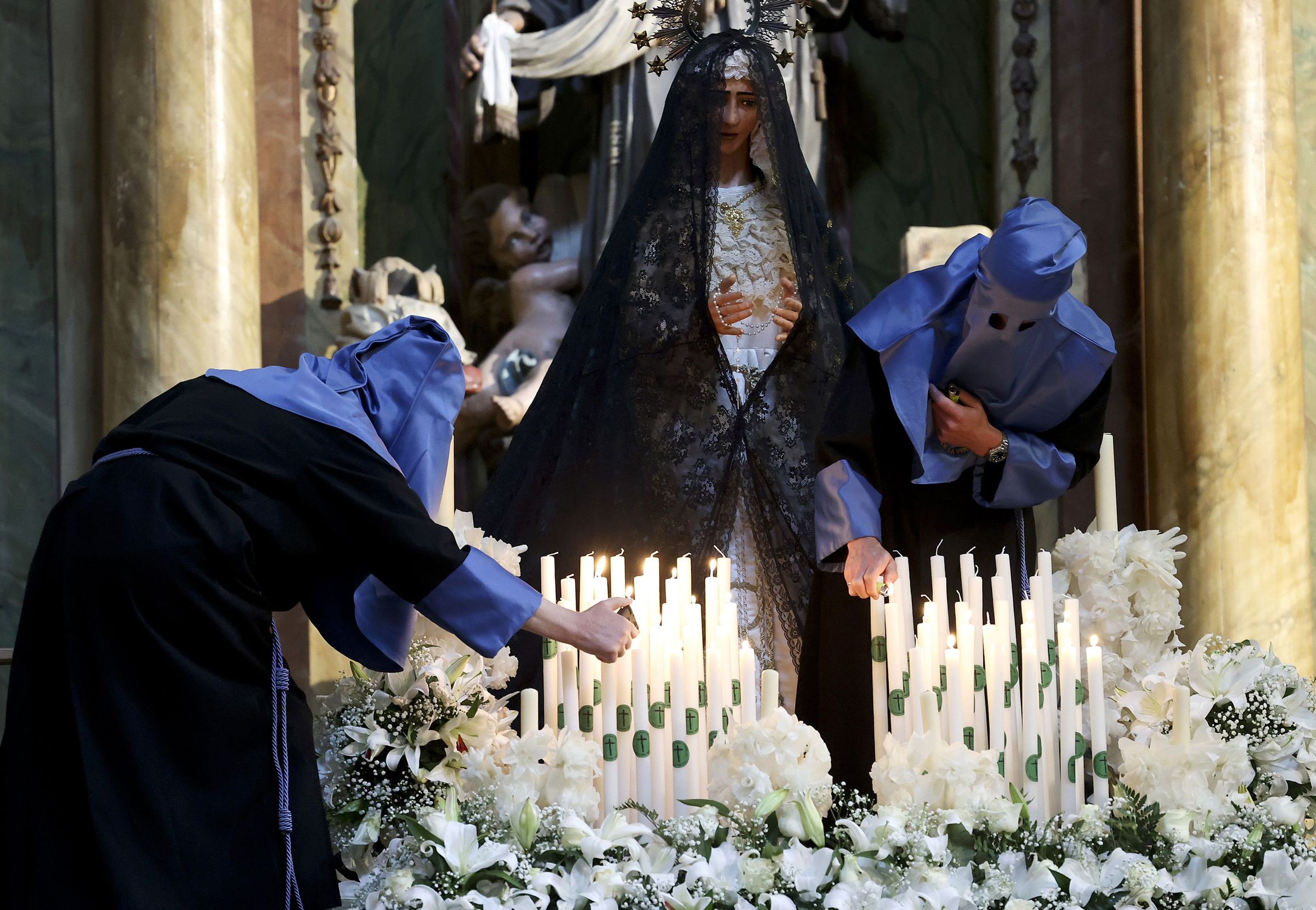 Encendido dos cirios dunha das imaxes da Procesin do Cristo Resucitado dentro da igrexa de san Francisco. 20/04/2025