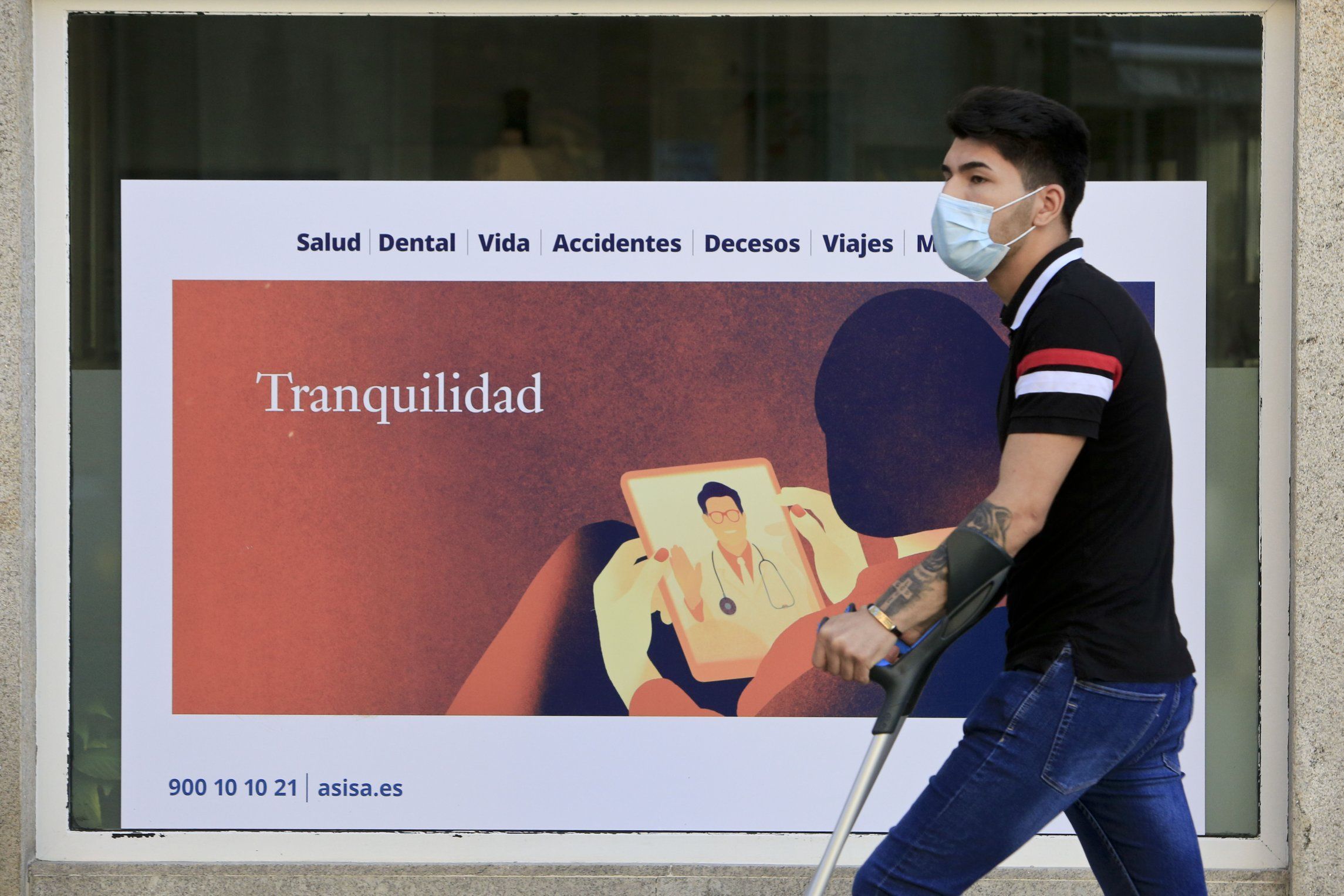 Ambiente no centro de Lugo o d�a previo a entrada en vigor das novas restrici�ns polo coronavirus. Un xove pasa � lado do cartel dunha aseguradora que ofrece  tranquilidade . 07/05/2021