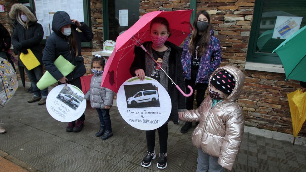 Escolares con carteles en defensa del actual sistema de transporte escolar, del que se encargan los taxistas locales