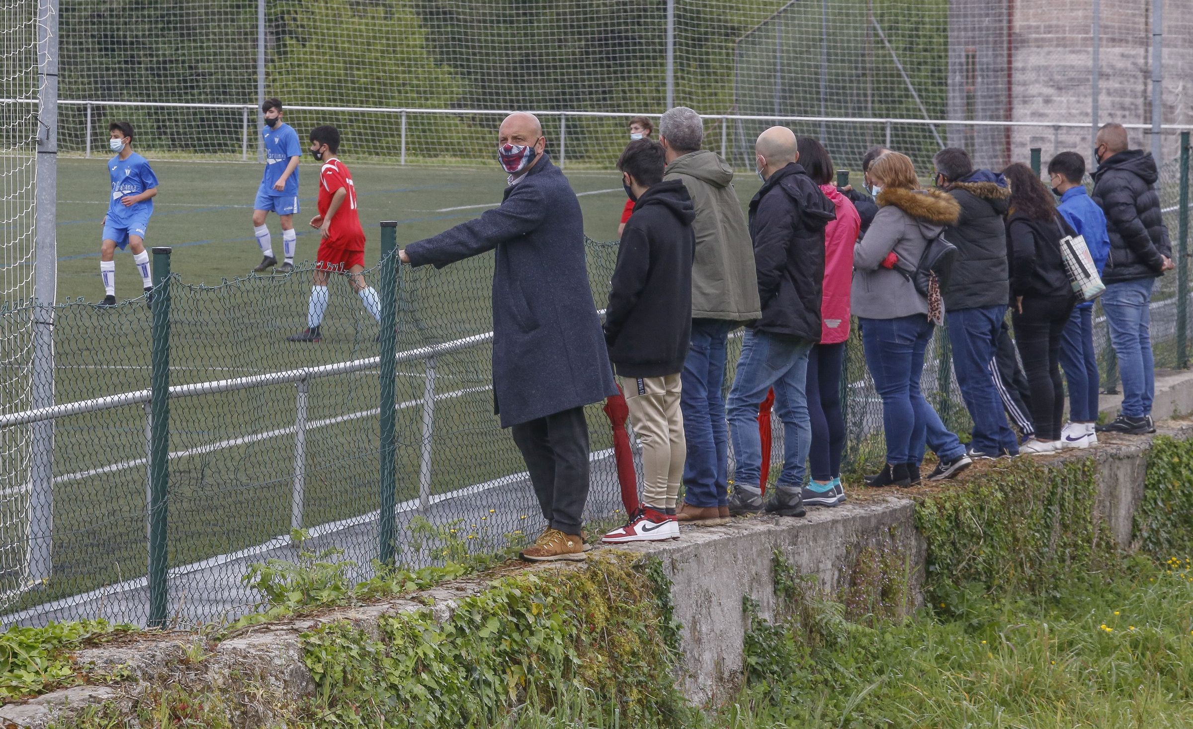 Campo municipal de futbol de villestro. Los padres no pueden entrar al campo y ven el partido todos juntos desde detrs del cierre.09/04/2021