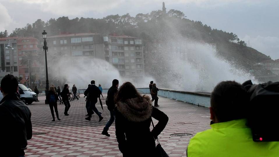 Las olas azotan el puerto de Baiona y sorprenden a los viandantes