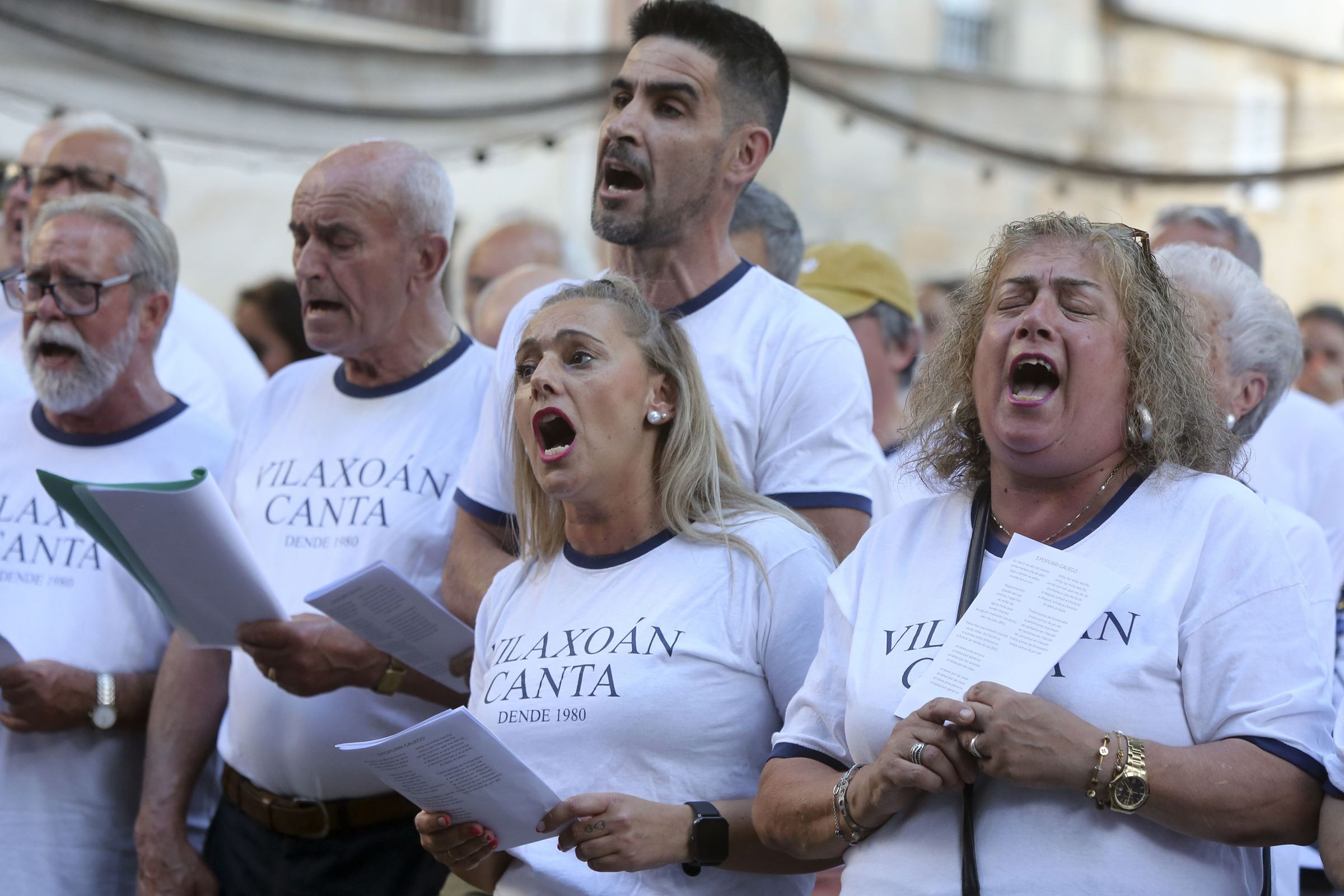 Os vecios de Vilaxon levan dende 1980 reunndose na praza da vila para cantar. 27/07/2024