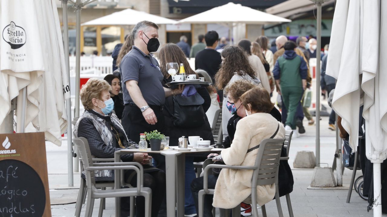 Un agente habla con dos clientes de un bar esta tarde en el Casco Vello vigués