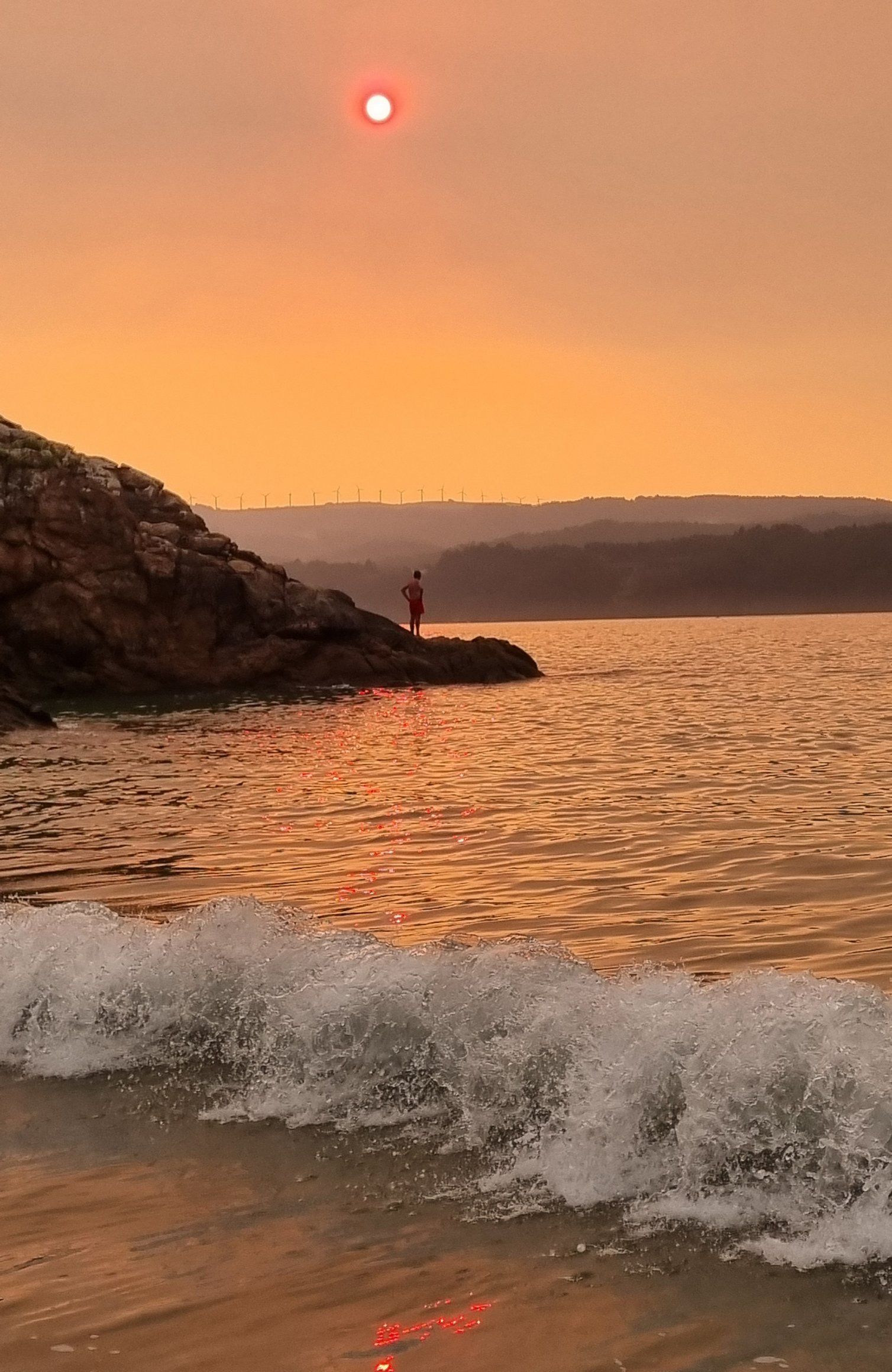 O fume dos incendios de Ourense chega ao outro extremo de Galicia. As se poda ver o ceo na praia de Area, en Viveiro. 15/08/2025