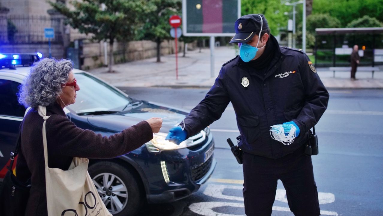 La Policía Nacional reparten mascarillas a usuarios del autobús en Ourense