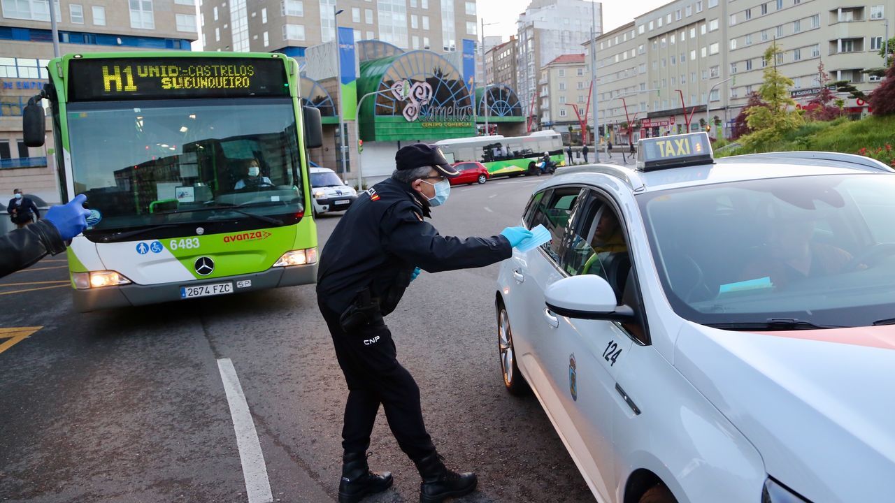 Policía Nacional, Local y Autonómica reparten mascarillas a transeúntes y conductores en la plaza de América de Vigo