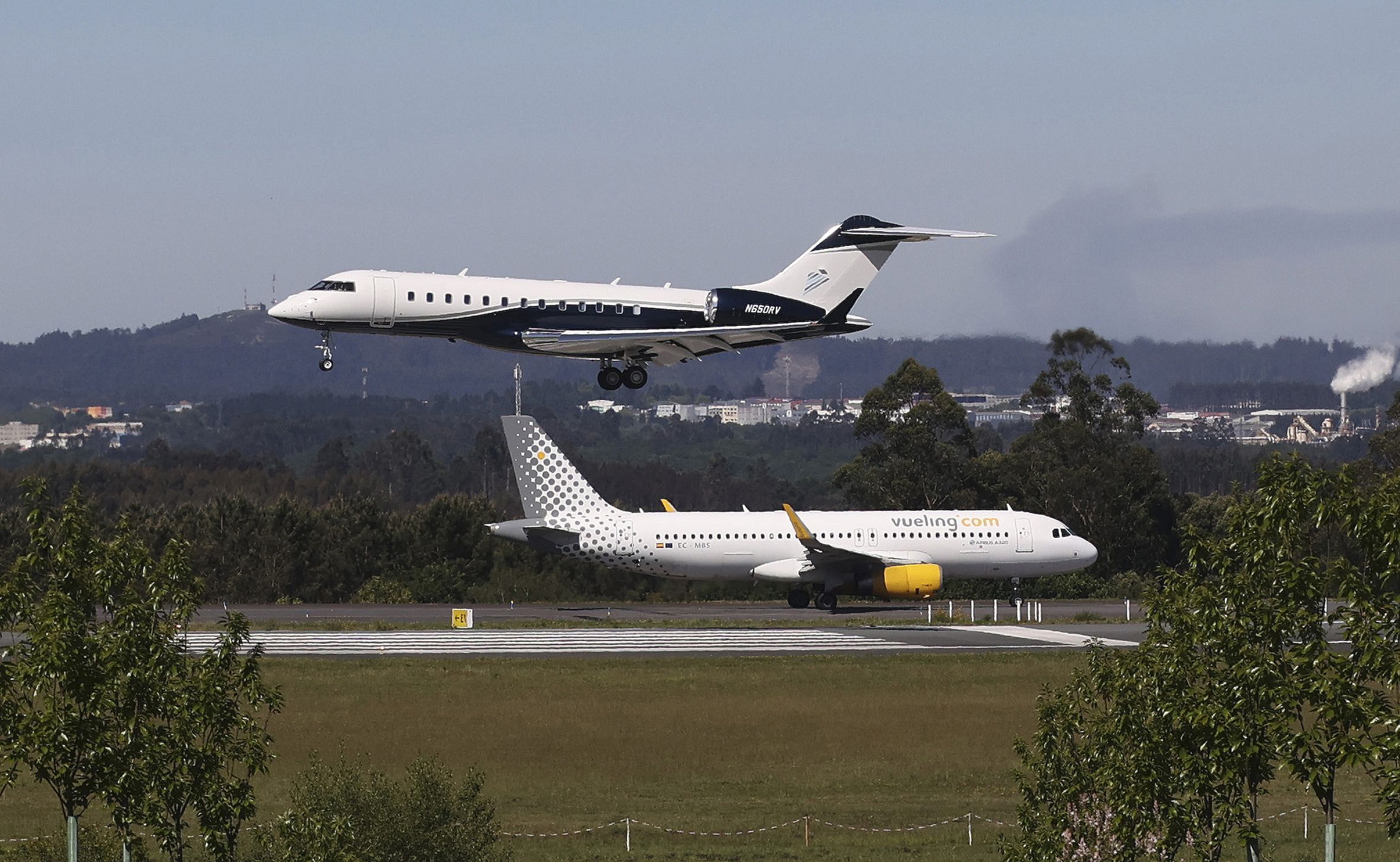 Aterrizaje de un avin mientras otro espera para despegar en el aeropuerto Rosala de Castro.